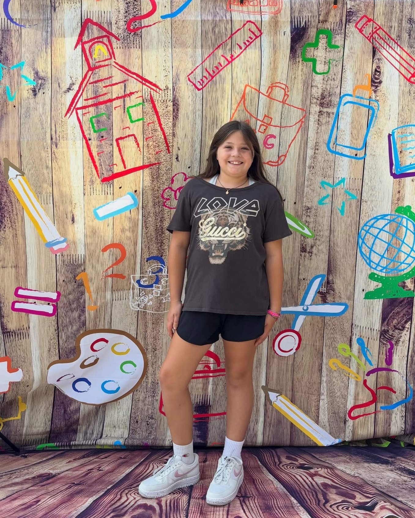 Girl in Gucci graphic tee and black shorts at Back 2 School Stroll