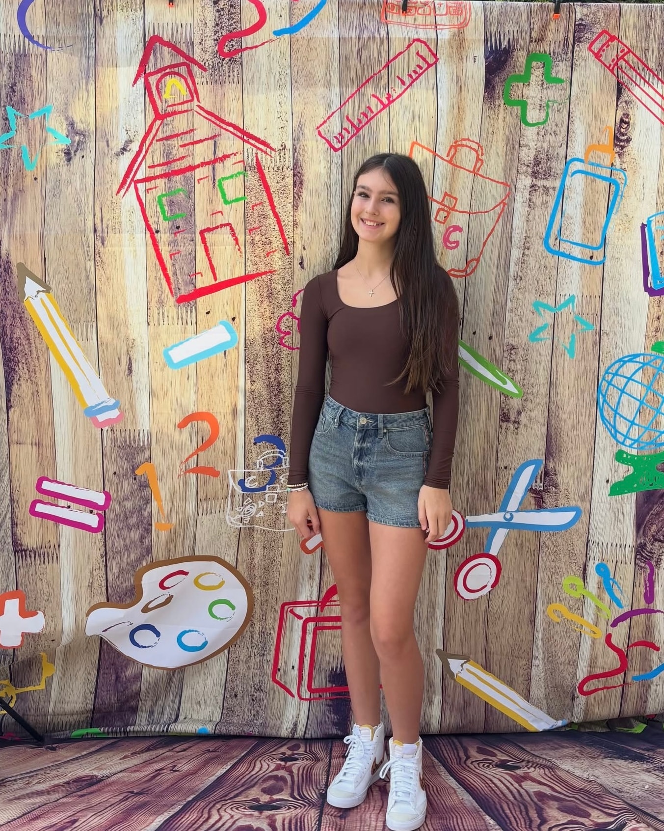 Teen girl in brown long-sleeve top and denim shorts at Back 2 School Stroll