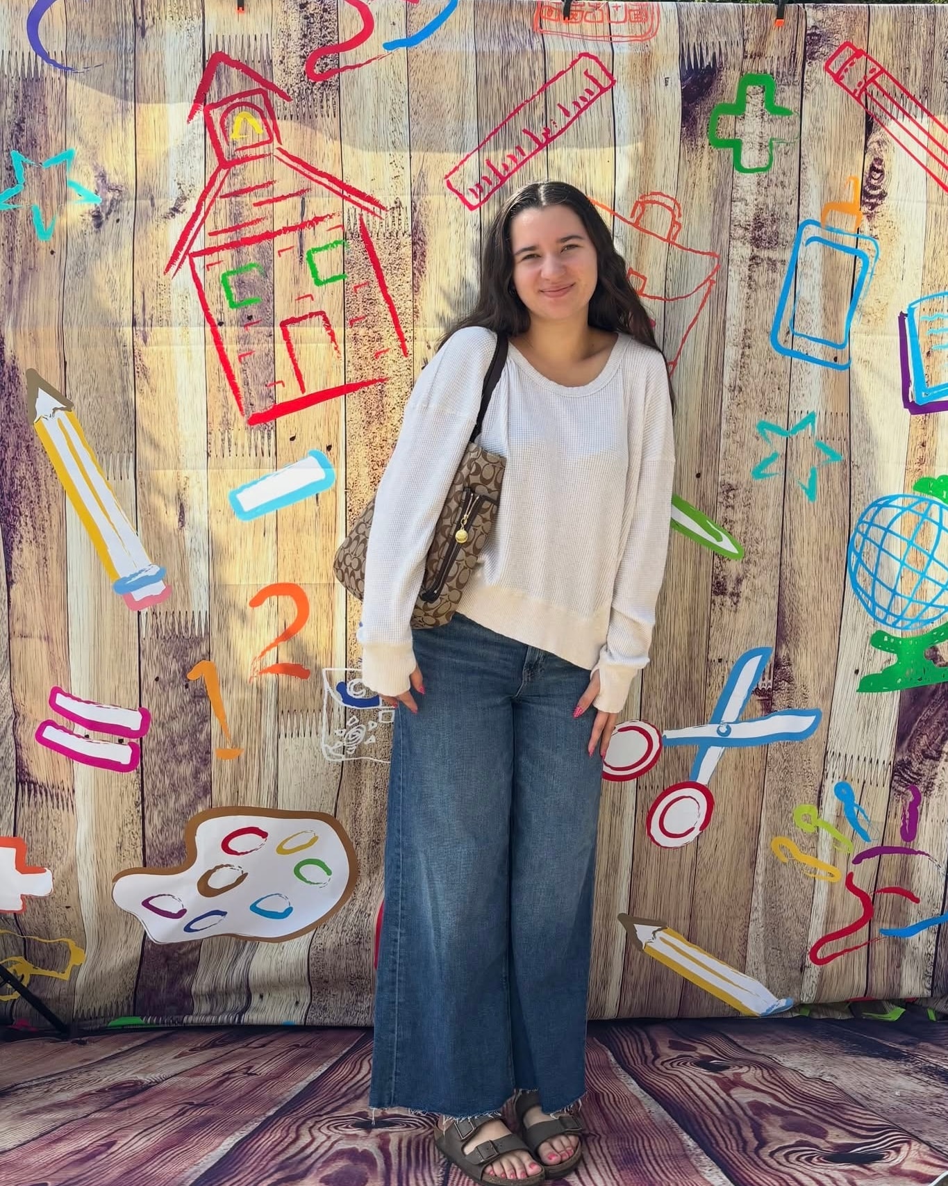 Teen in white waffle sweater and wide-leg jeans with Coach bag at Back 2 School Stroll