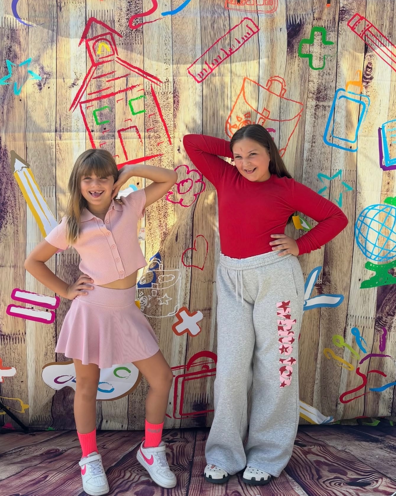 Two girls in pink skirt set and red top posing at Back 2 School Stroll