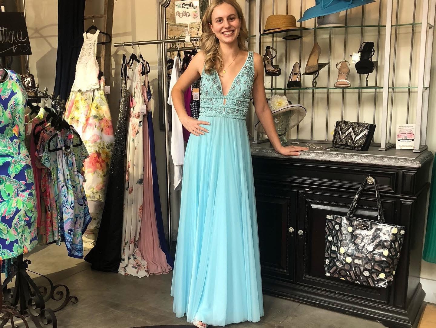 Young woman in aqua beaded prom gown at Twice Blessed boutique