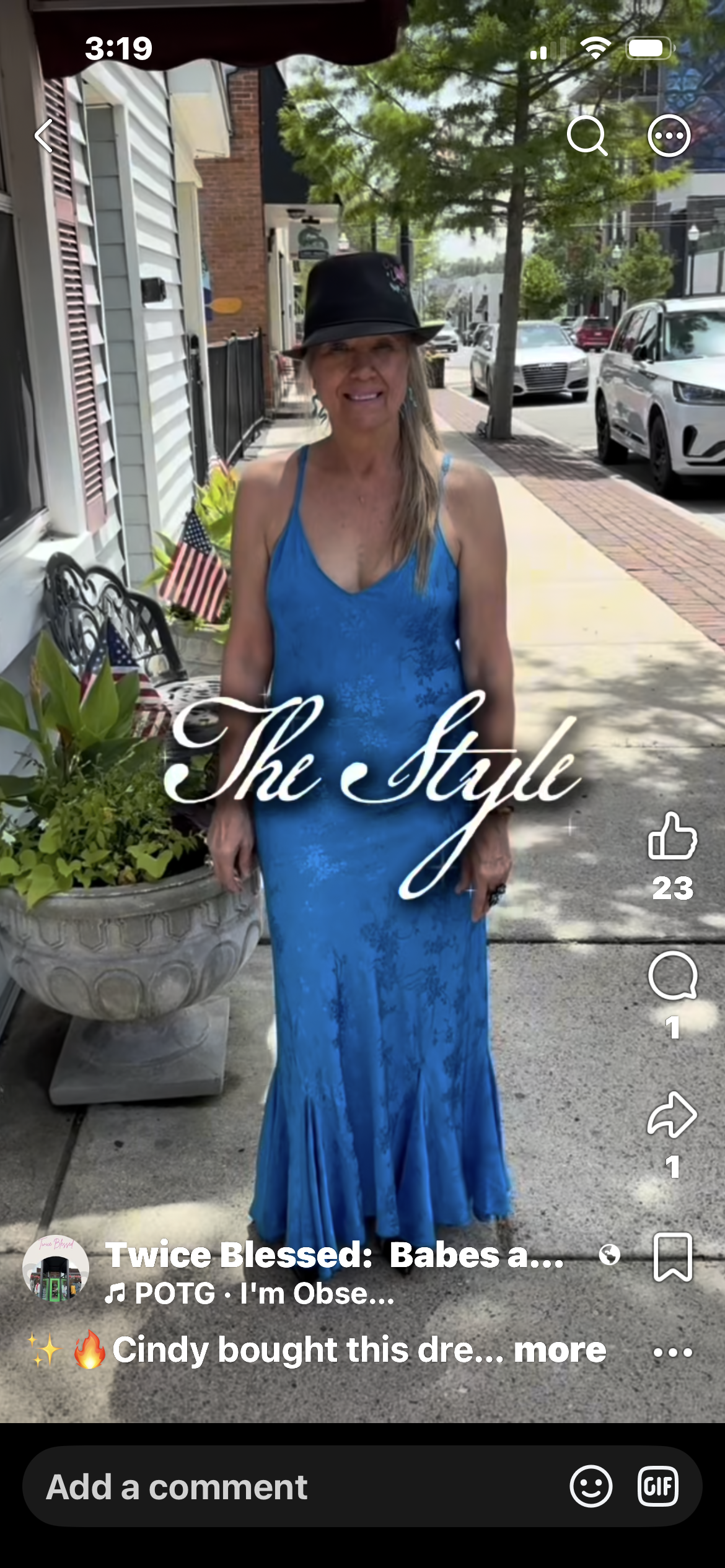 Woman in stunning blue mermaid gown on the street outside Twice Blessed boutique
