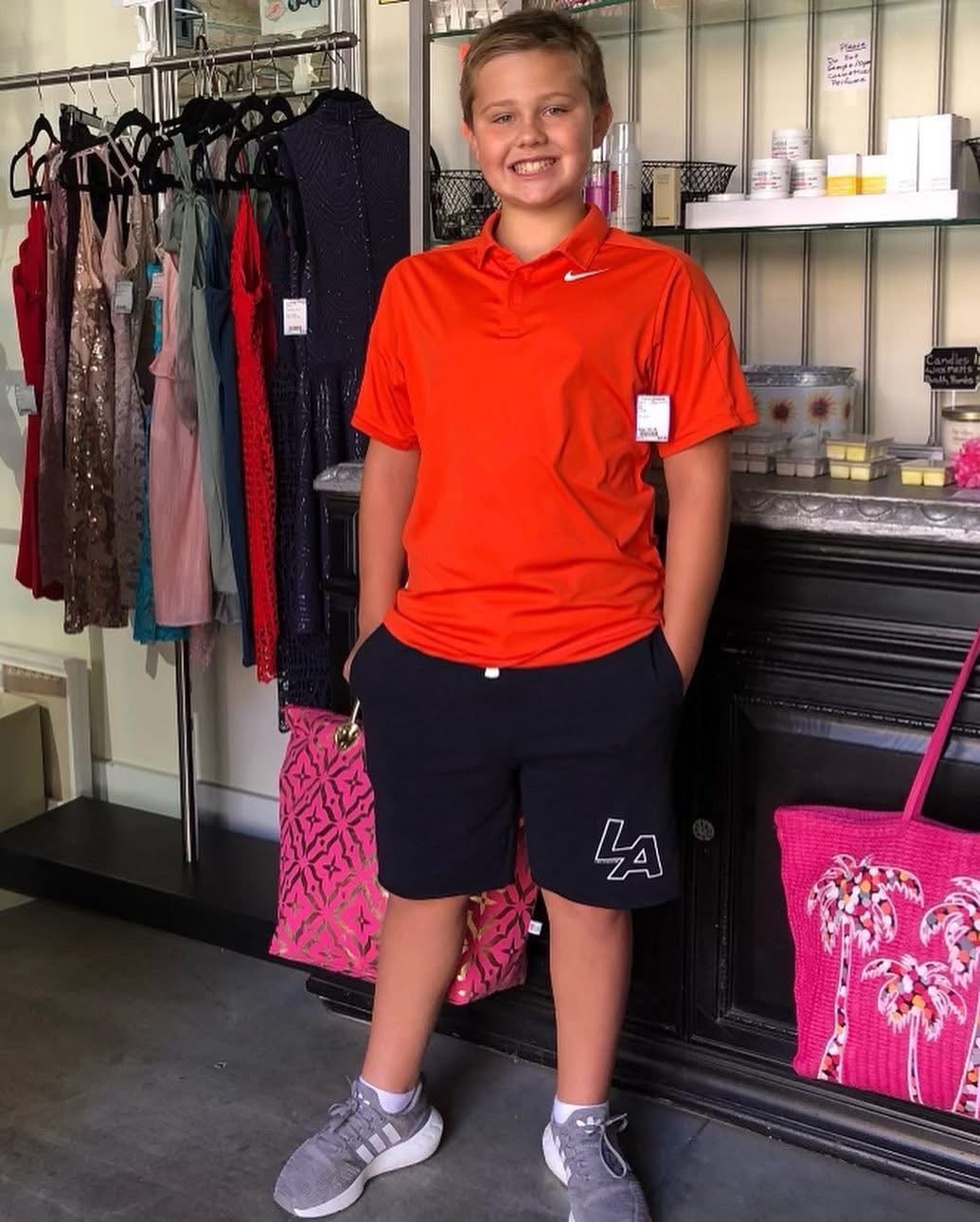 Boy in orange Nike polo and navy shorts at Twice Blessed boutique