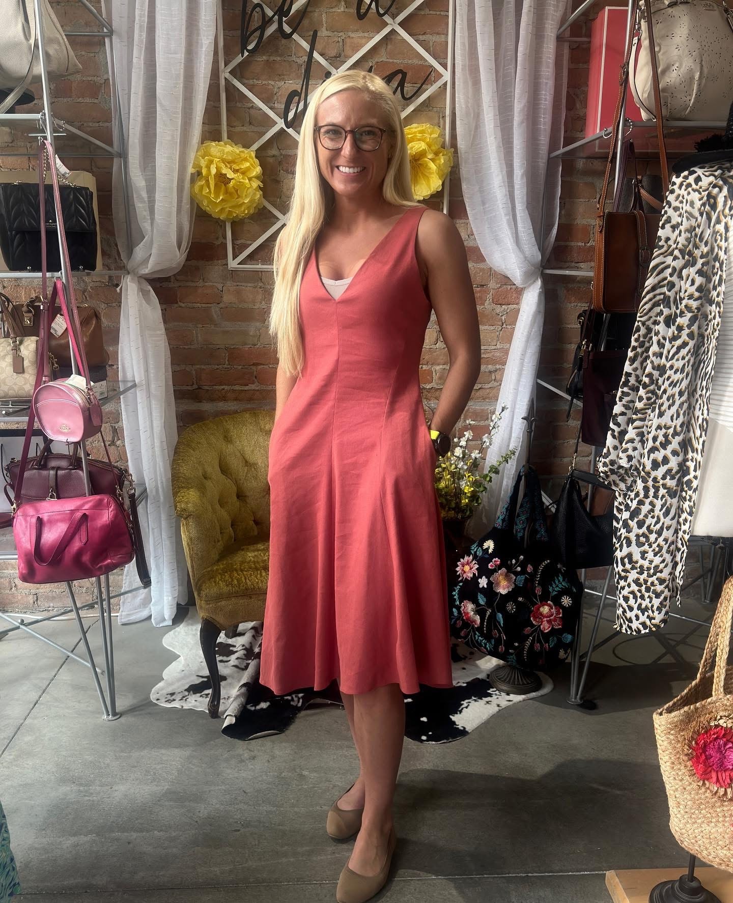 Woman in coral v-neck midi dress at Twice Blessed boutique