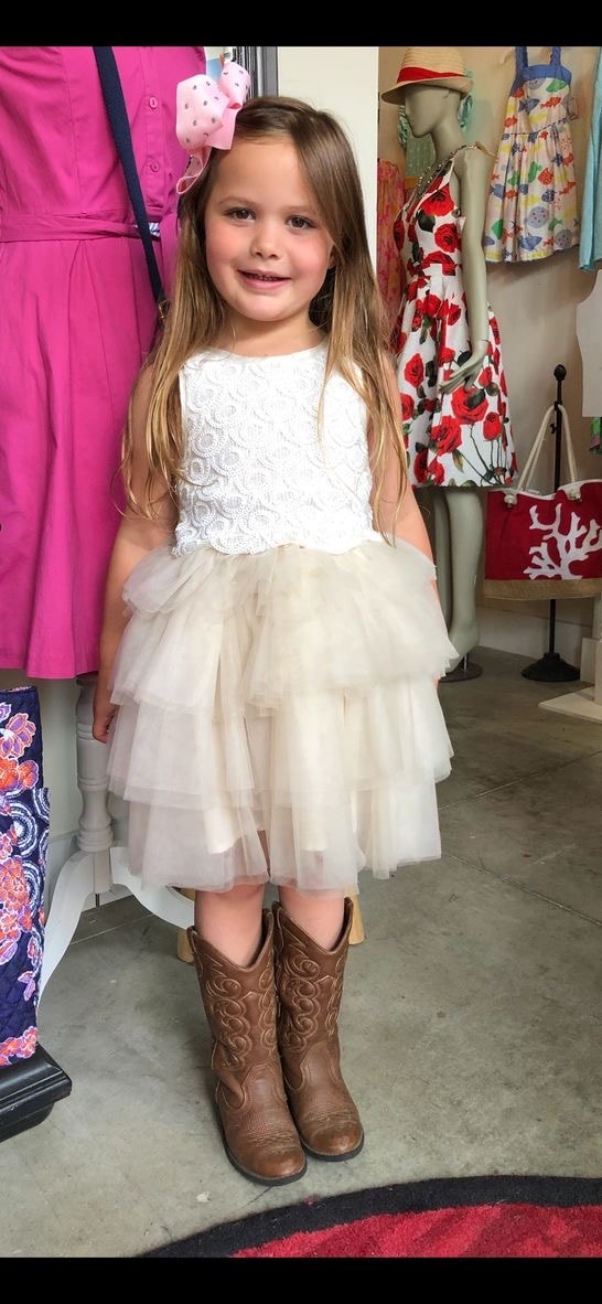 Adorable little girl in white lace tulle dress with cowboy boots at Twice Blessed boutique
