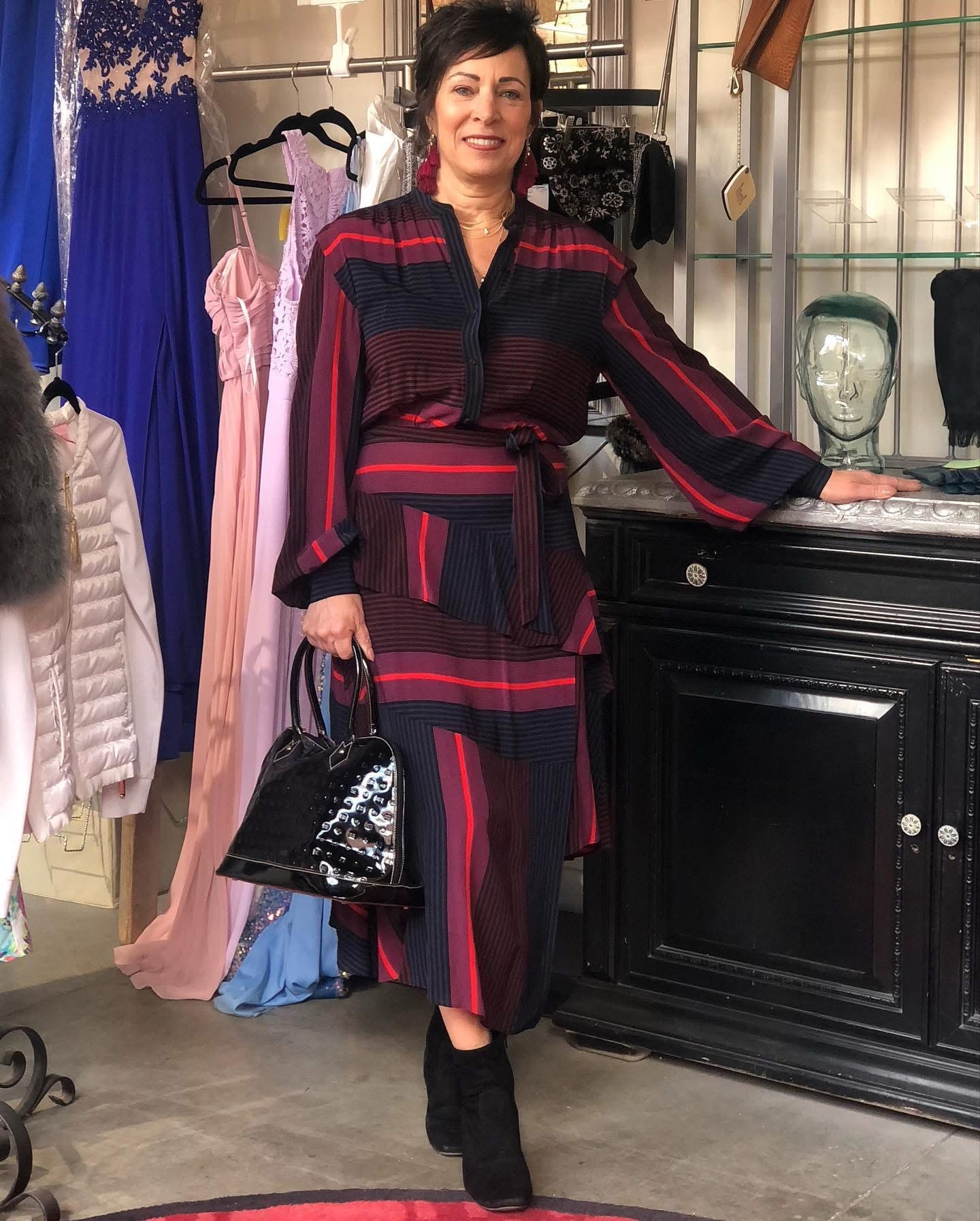 Woman in red and black striped outfit with patent leather bag at Twice Blessed boutique