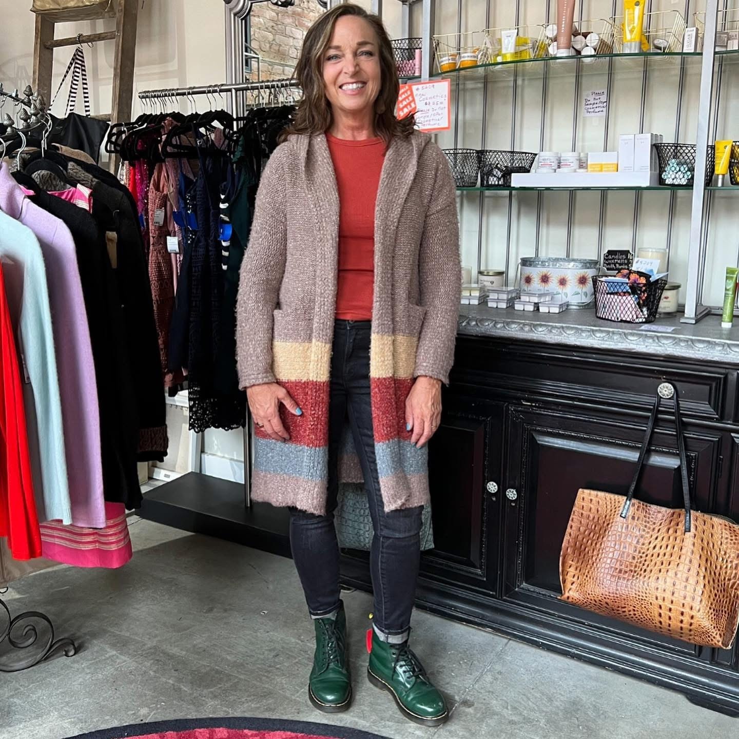 Woman in colorful striped cardigan and green boots at Twice Blessed boutique