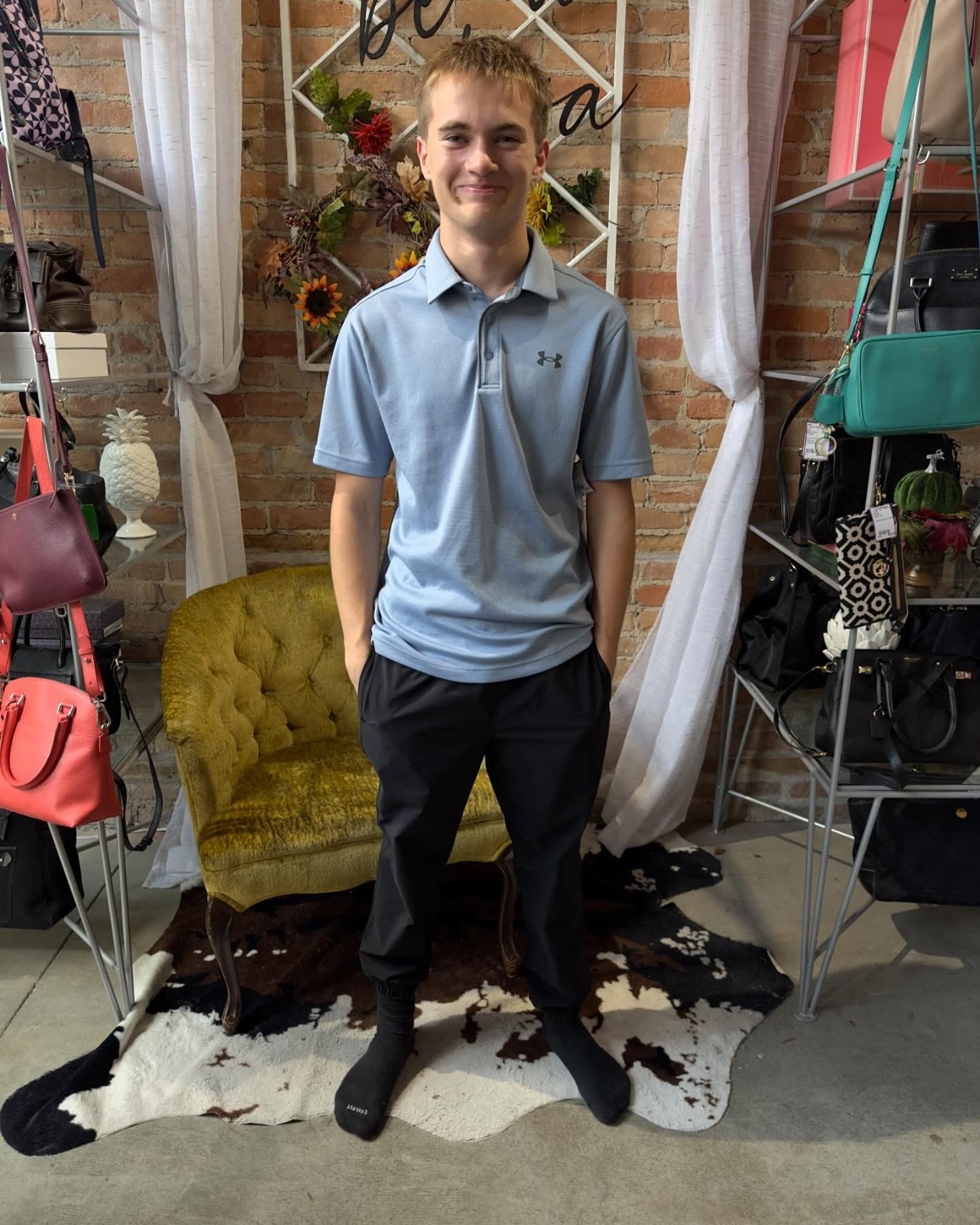 Teen boy in light blue Under Armour polo and black pants at Twice Blessed boutique