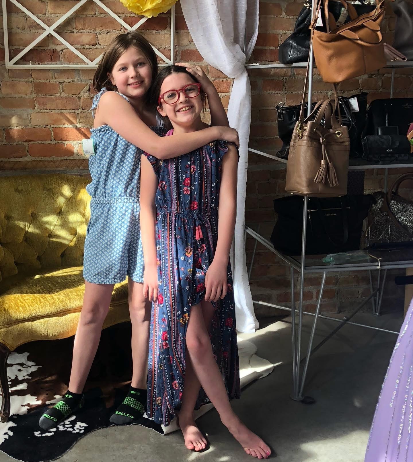 Two girls hugging in summer dresses at Twice Blessed boutique