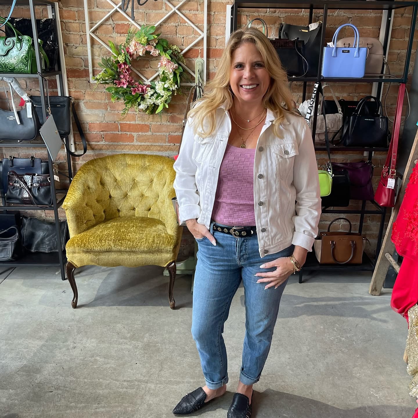 Woman in white denim jacket and pink top with jeans at Twice Blessed boutique