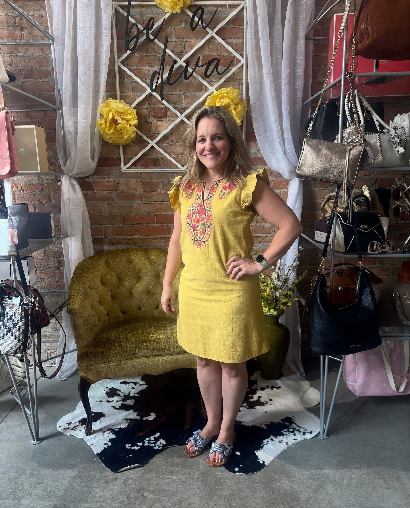 Woman in yellow embroidered ruffle-sleeve dress at Twice Blessed boutique