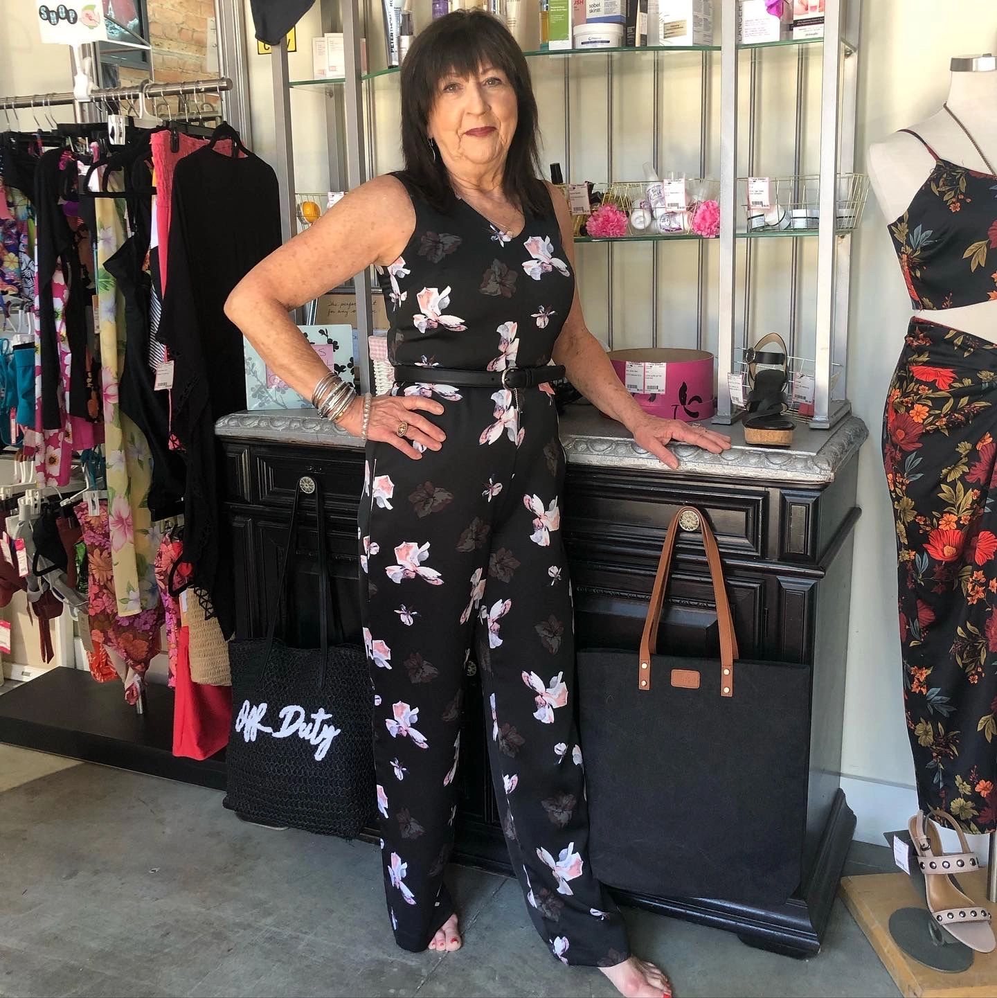 Woman in black floral jumpsuit at boutique