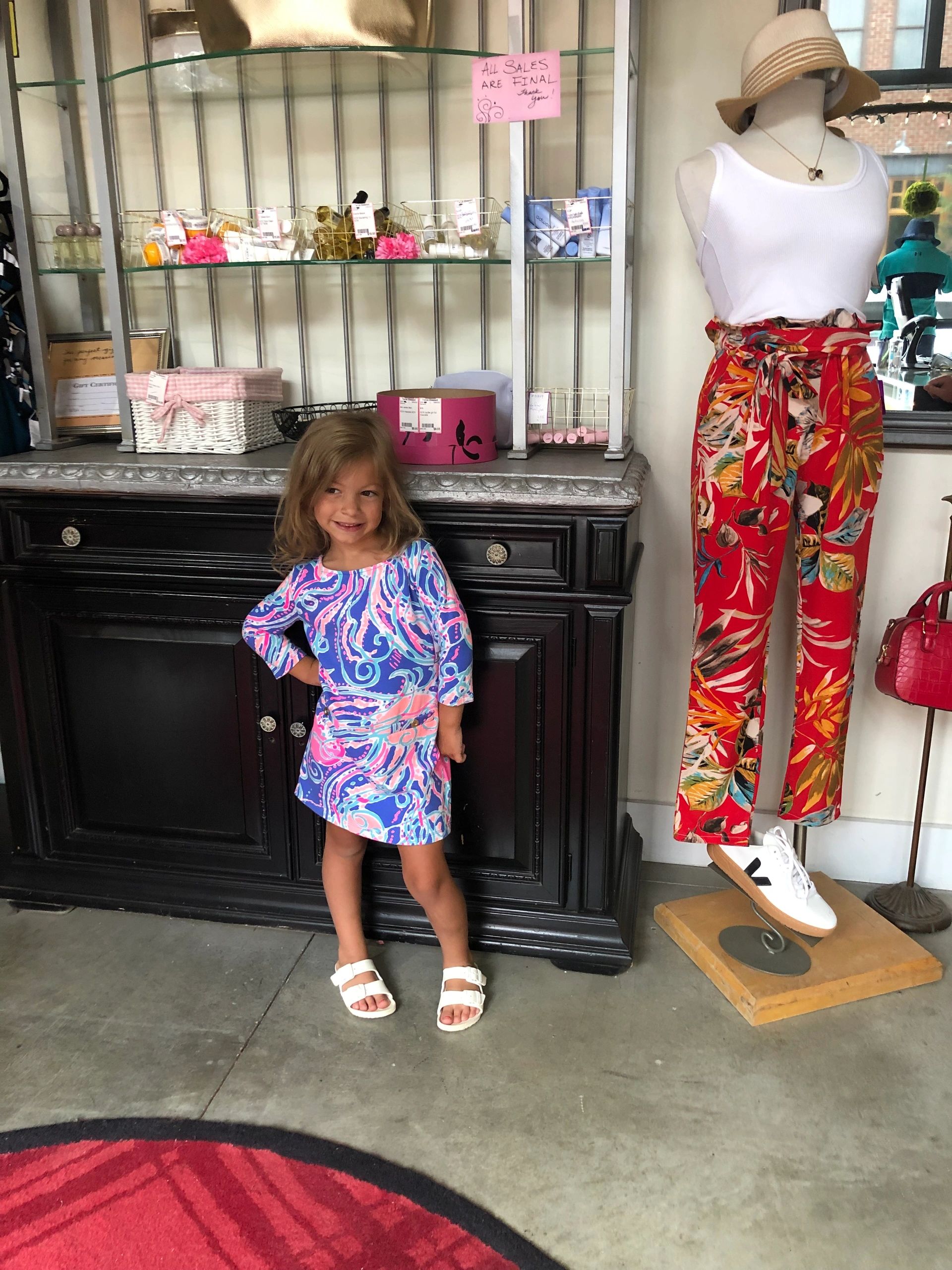 Girl in blue and pink dress at boutique window