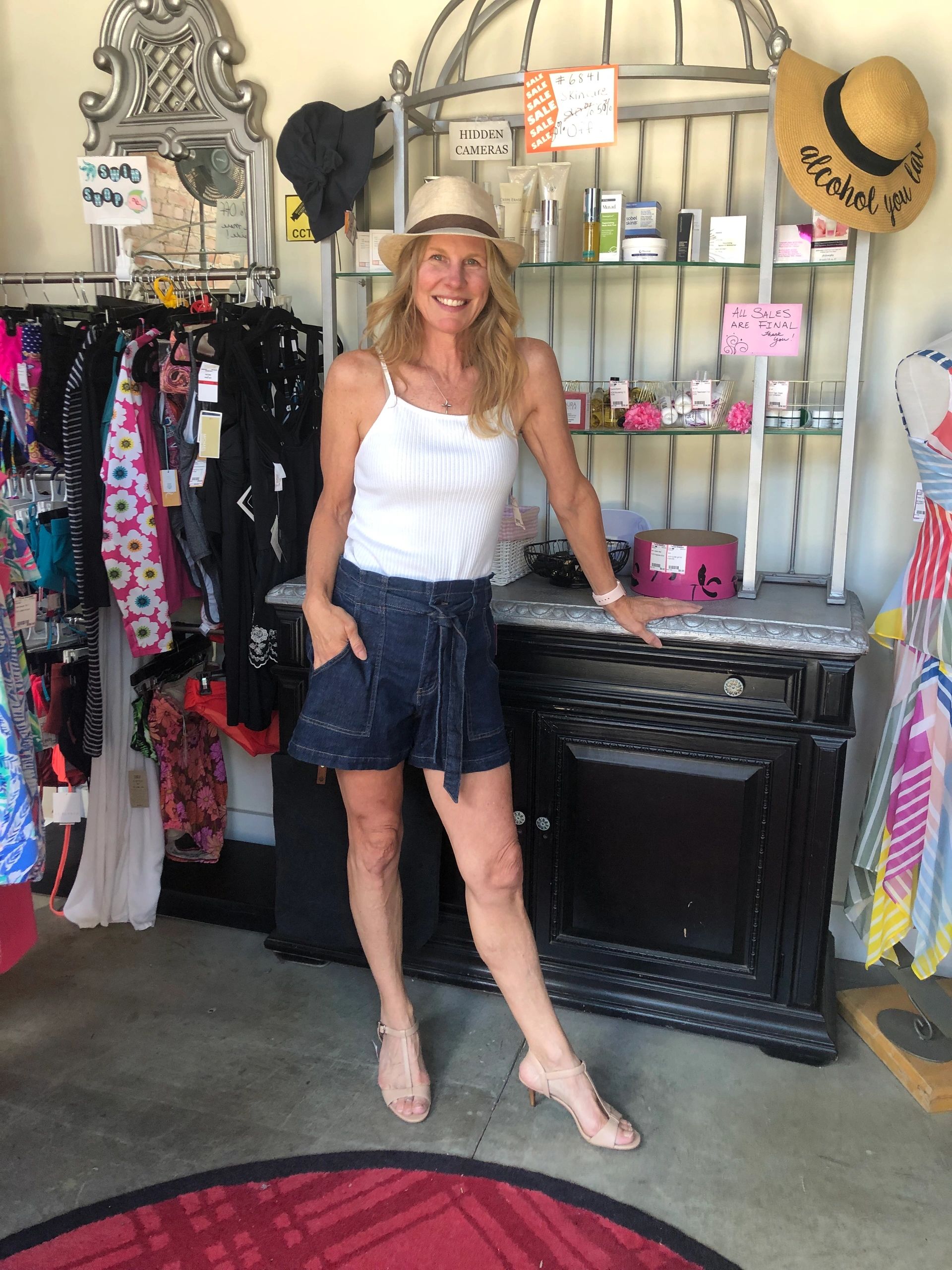 Woman in white tank and denim shorts at boutique