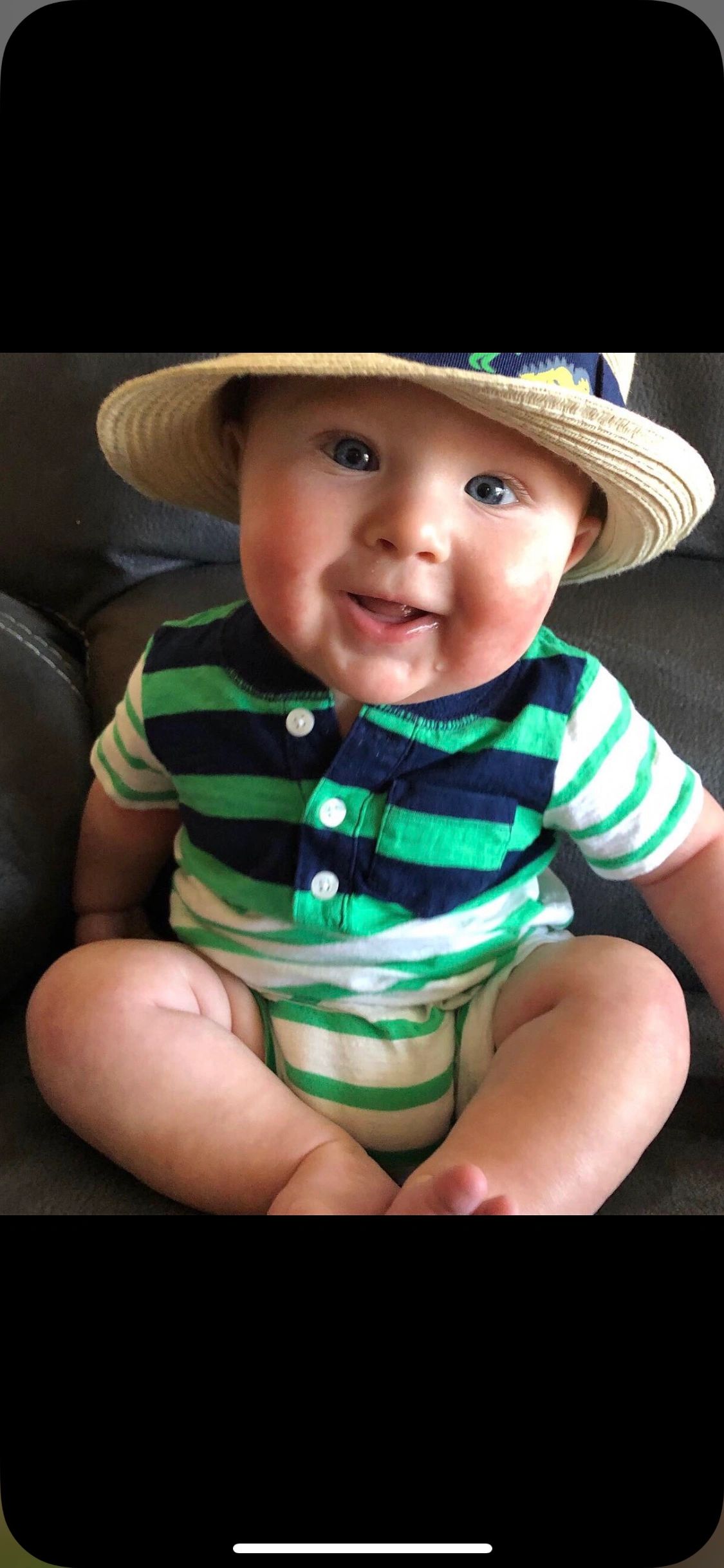 Smiling baby in straw hat and striped shirt